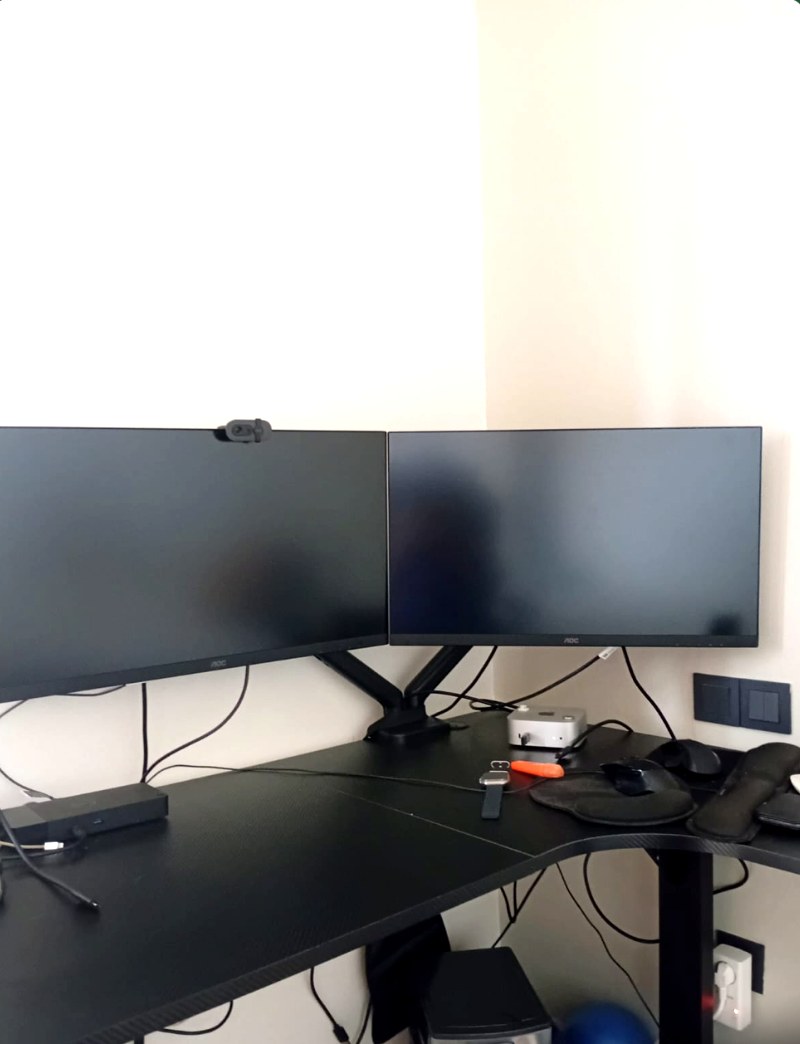 Setup bureau : deux écrans AOC sur bras double, bureau d'angle noir, station Dell